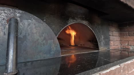 fire flickers within a traditional pizza oven.