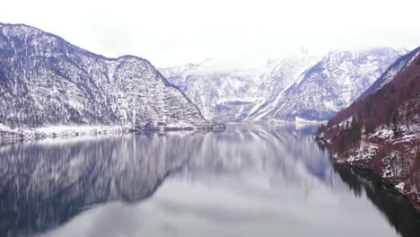 Aerial-shot-of-spectacular-Alpine-valley-with-mountains-reflecting-on-lake-below