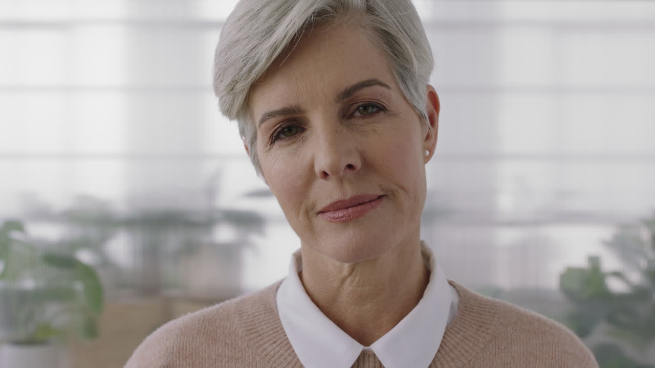 retrato de una mujer caucásica madura y elegante que mira seriamente pensativa a la cámara