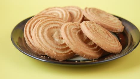 plate of spiral cookies on a yellow background