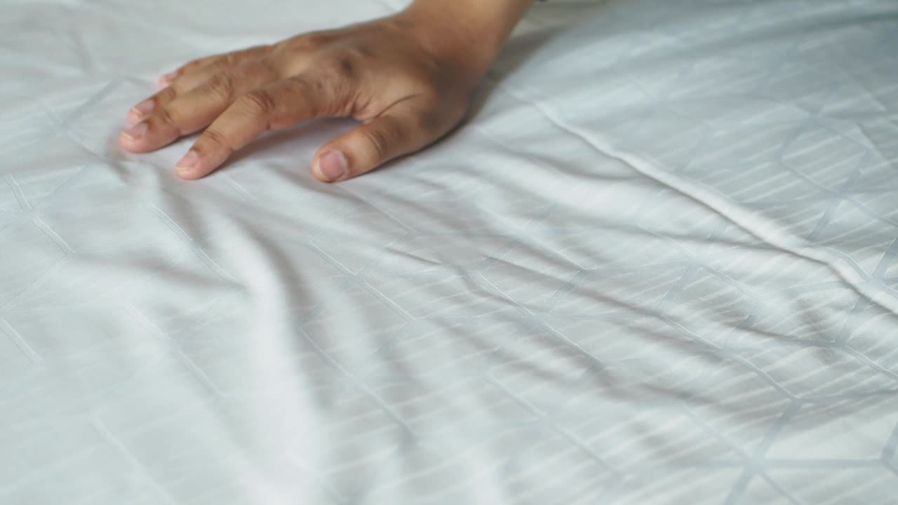 침대 시트를 만지는 손