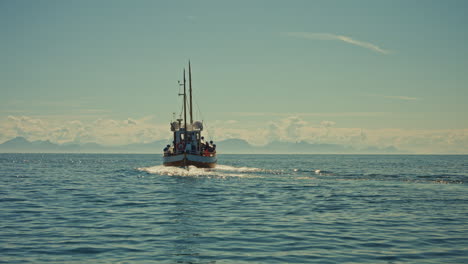 close up shot of a small fishing boat navigating on the norwegian sea, close to the lofoten islands, norway