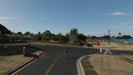 hombre en monopatín eléctrico en una zona residencial usando una función de vuelo automático de drones para registrar sus movimientos en el modo "sígueme"