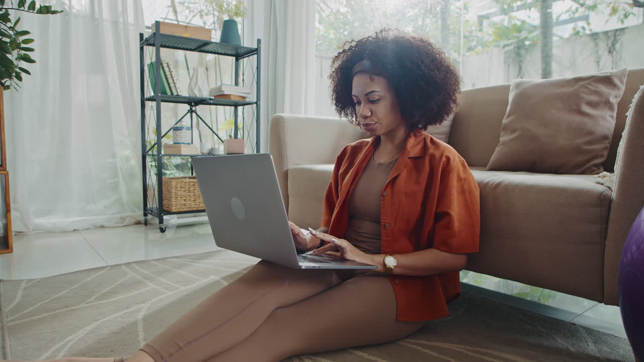Busy Woman Sitting on Floor while Working on Laptop from Home