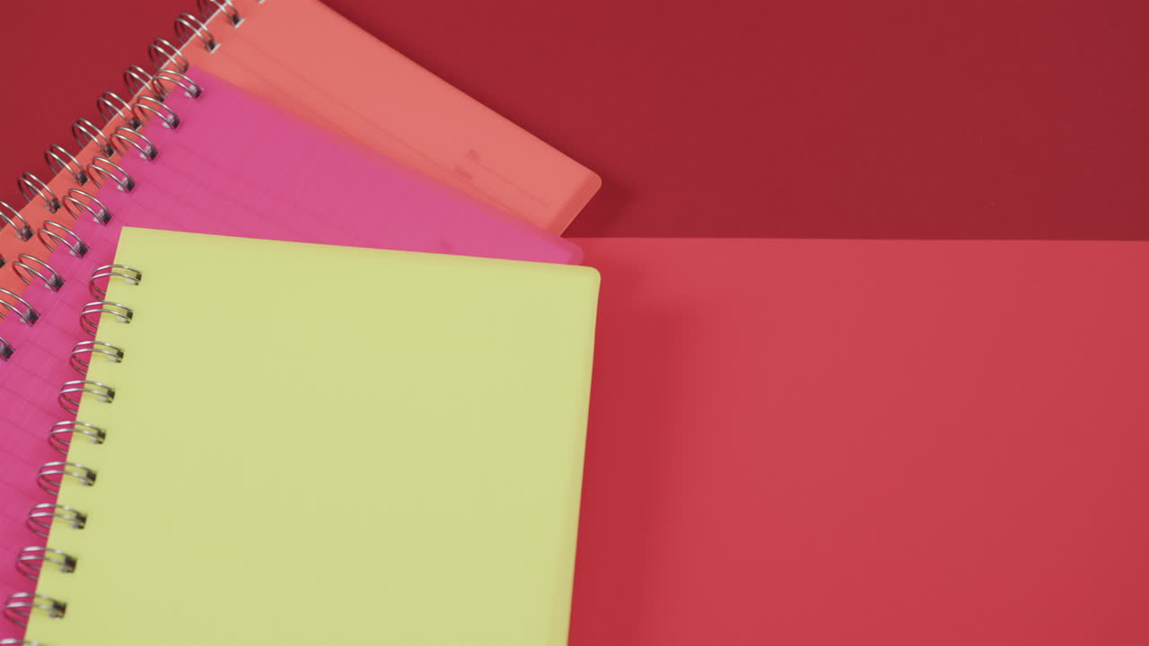 A vibrant composition featuring a yellow notebook on a red background, with copy space