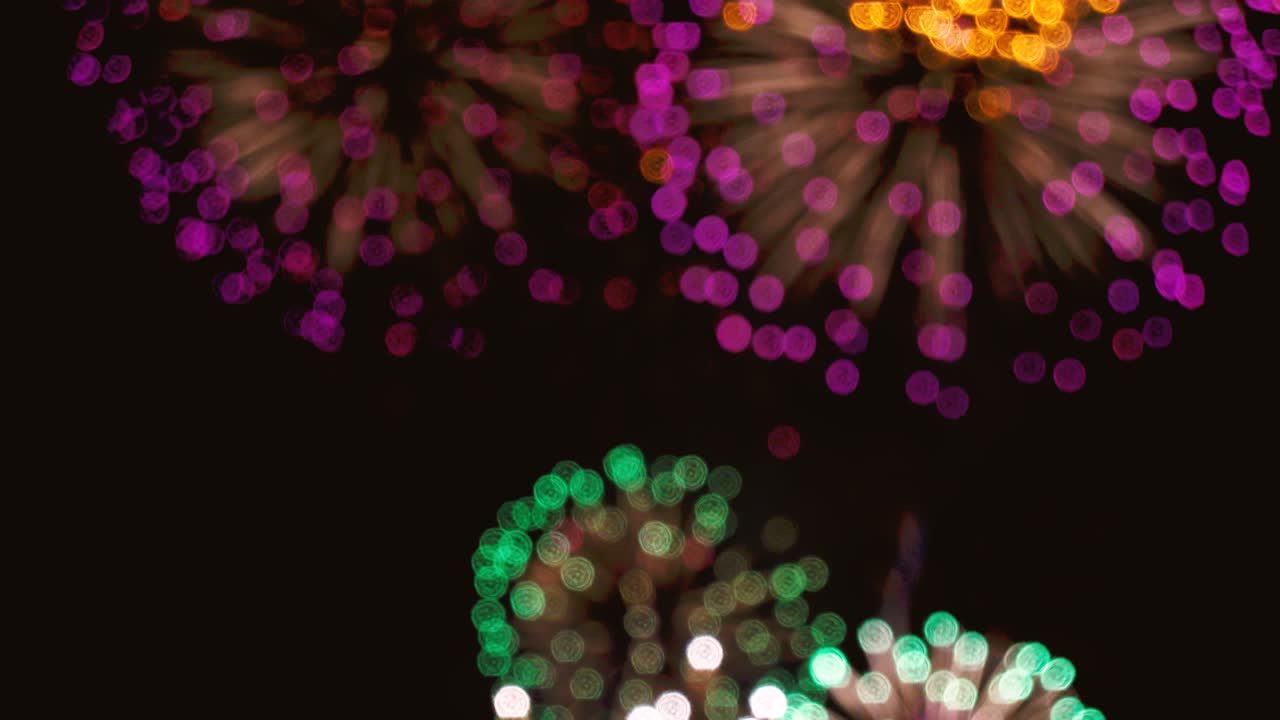 bucle sin costuras de fondo de fuegos artificiales reales. borrón abstracto de fuegos artificiales dorados brillantes reales con luces bokeh en el cielo nocturno. espectáculo de fuelos artificiales brillantes. celebración de fuegos nucleares de la víspera de año nuevo