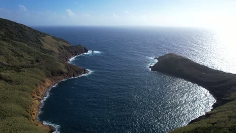 Drone-approaching-figure-eight-shaped-dual-bay-behind-Monte-da-Guia-in-Horta