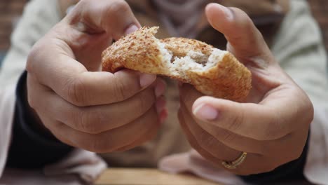 close up of woman's hands holding a freshly baked loaf of bread