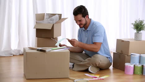 Man-sitting-on-floorand-choosing-colour