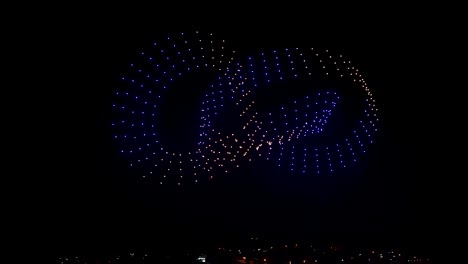 flying drones creating 3d models moving on night sky over the city lights, exceptional show