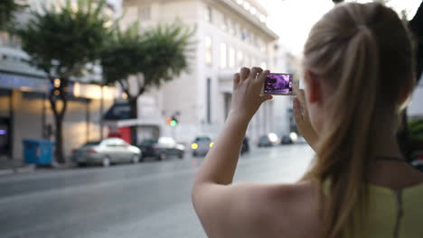 woman photographing an urban street