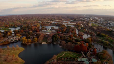 Glencoe,-Illinois,-USA-:-Aerial-drone-forward-moving-shot-over-building-in-Chicago-Botanic-Garden-with-small-lakes-during-evening-time