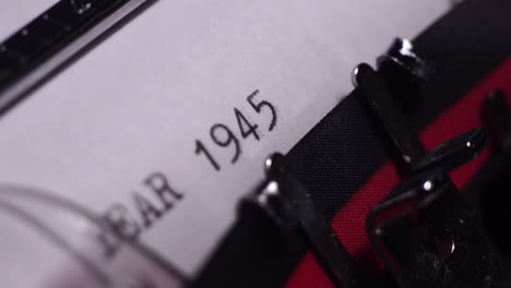 year 1945, typing on white paper in vintage typewriter, macro close up