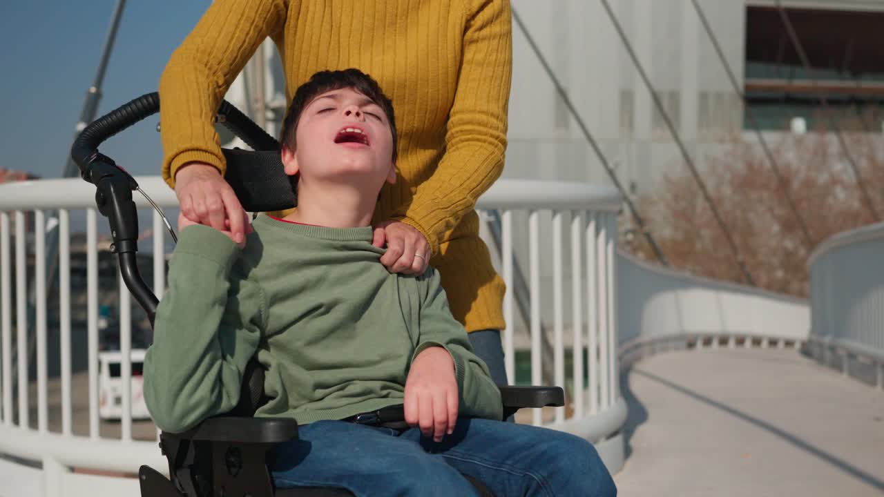 Child in wheelchair with mother on a bridge