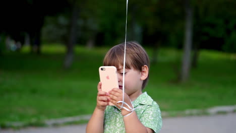 small boy with balloons. little boy playing with yellow balloon and smartphone