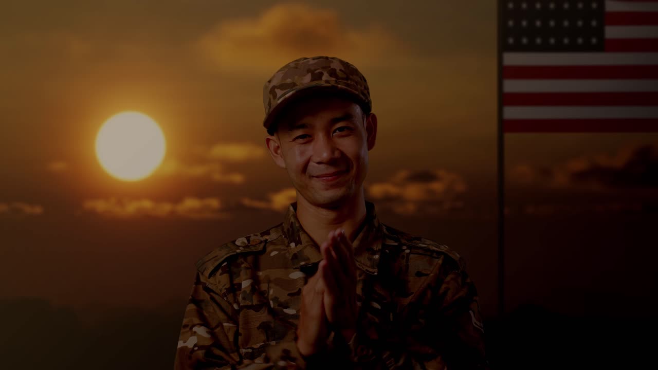 Close Up Of Asian Man Soldier Smiling And Clapping His Hands While Standing With Flag Of The United States, Sunset Time