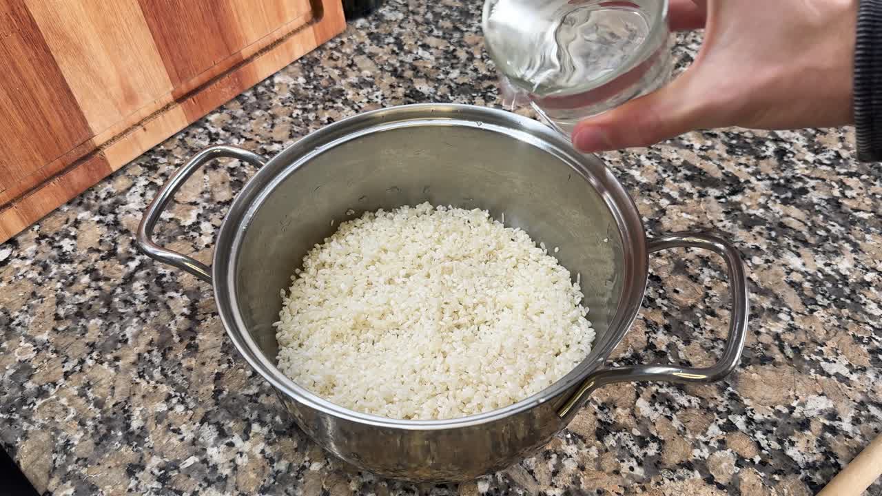 Water is Being Poured Into a Pot of Rice to Prepare For Making Onigiri - Close Up
