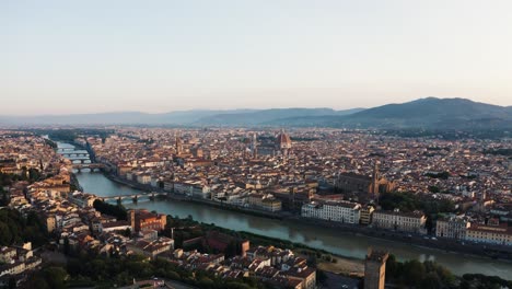 backwards aerial of florence with arno river and the duomo