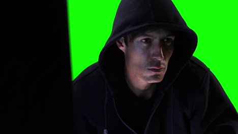 Hacker using computer with green screen