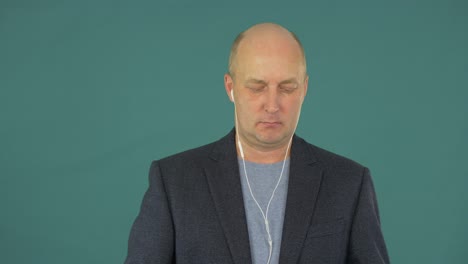 adult man using smartphone for listening music in headphone