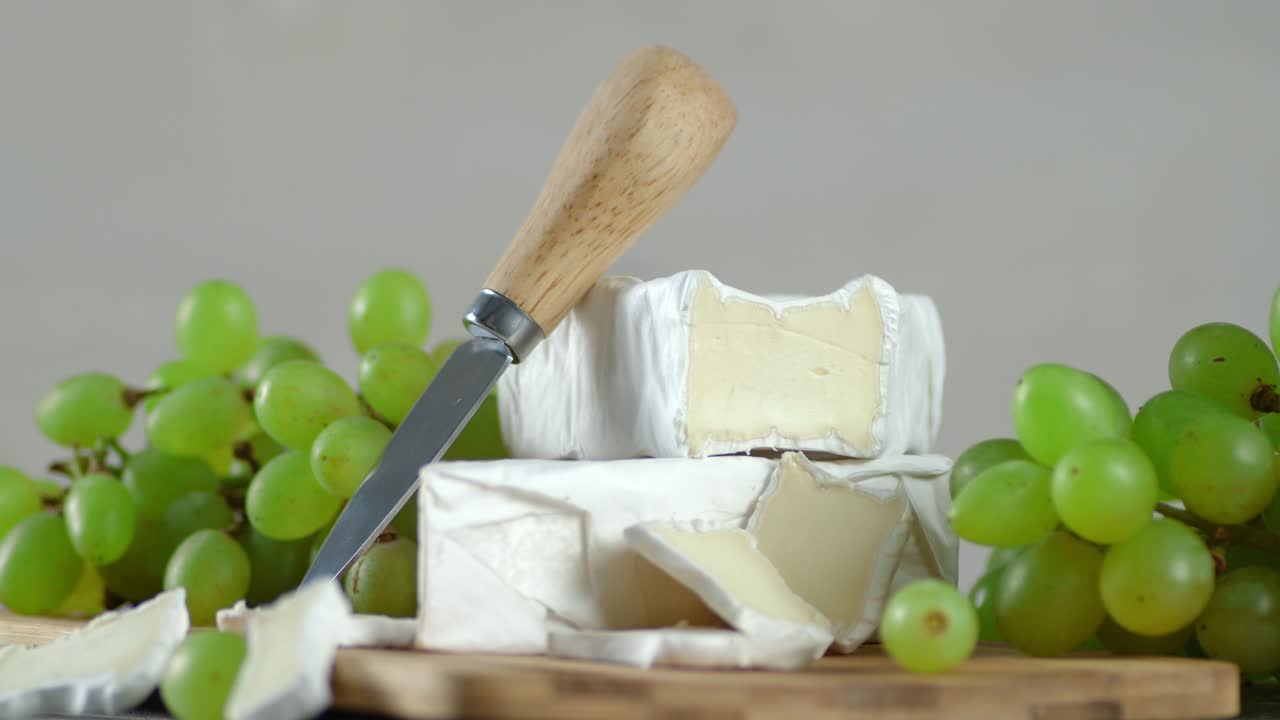 queso camembert con uvas girando lentamente.
