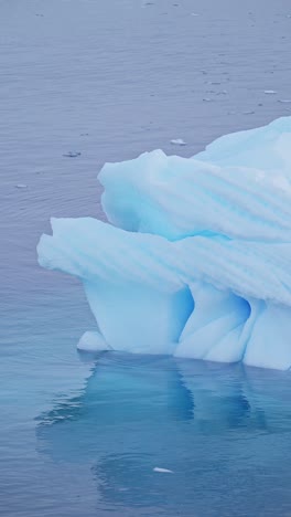 blue iceberg ice formation close up detail in antarctica, vertical nature video for social media, instagram reels and tiktok of sea icebergs amazing beautiful patterns in antarctic peninsula ocean