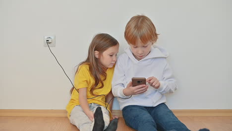 Niño-Y-Niña-Con-Un-Teléfono-Inteligente-Usando-Una-Aplicación