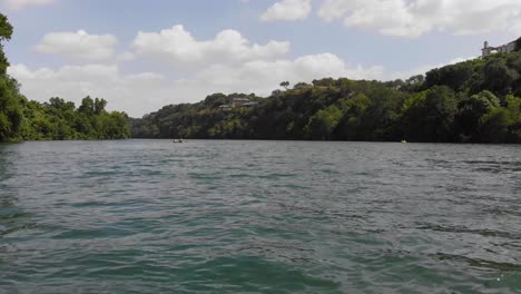 Low-drone-shot-of-kayakers-on-ladybird-lake,-shot-approaches-people-from-behind