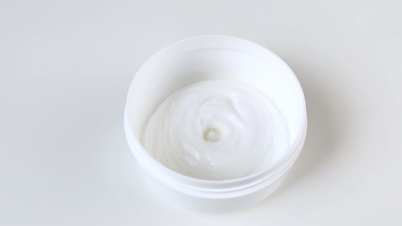 크림은 플라스틱 둥근 항아리에 부어집니다.