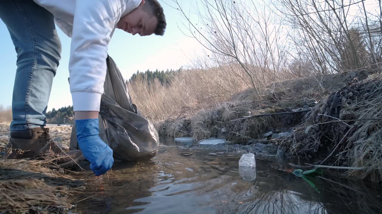trabajo en equipo limpiando plástico en la playa. voluntarios recogen basura en una bolsa de basura. contaminación plástica y concepto de problema ambiental. limpieza voluntaria de la naturaleza del plástico. ecologización del planeta
