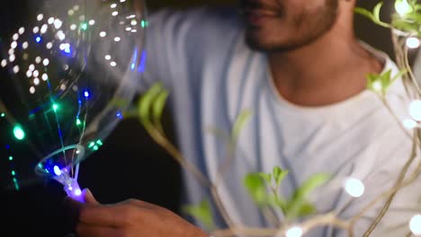 Teenage-young-boy-decorating-balloon-with-colorful-lights-for-party-celebrations,-slow-motion