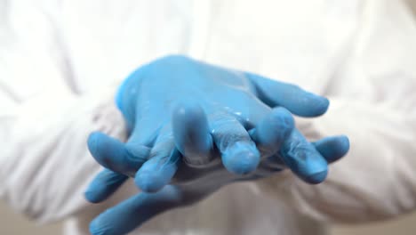 doctor dressed in ppe performing a proper cleaning of hands with gel before attending patients