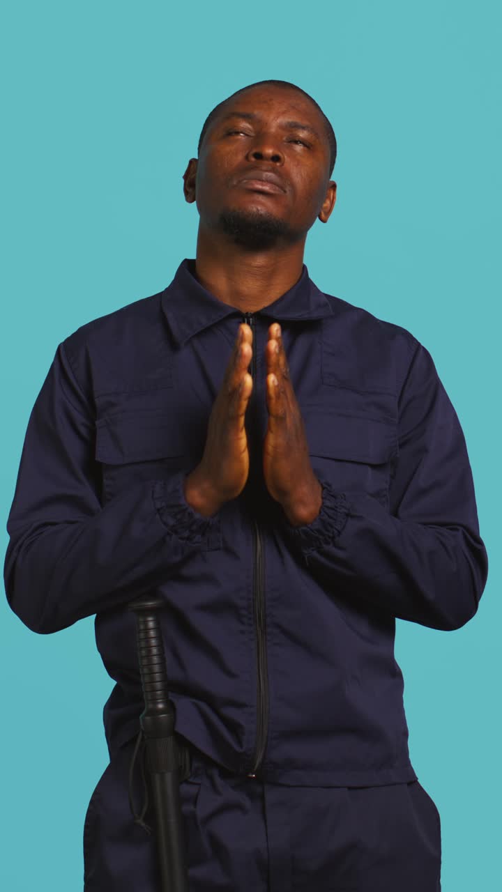 African American Man in Uniform Praying with Hands Together