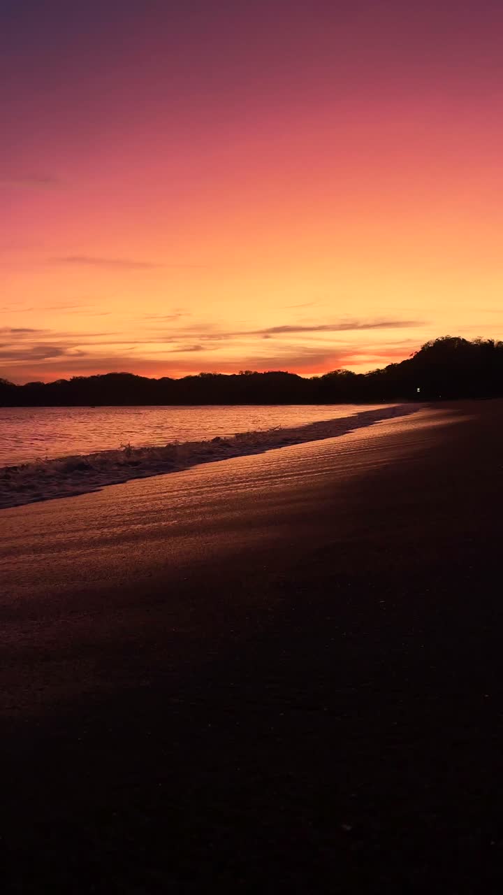 Stunning sunset landscape with tropical colors and ocean waves on the shore.