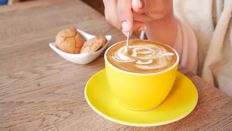 woman enjoying a latte art coffee at a cafe