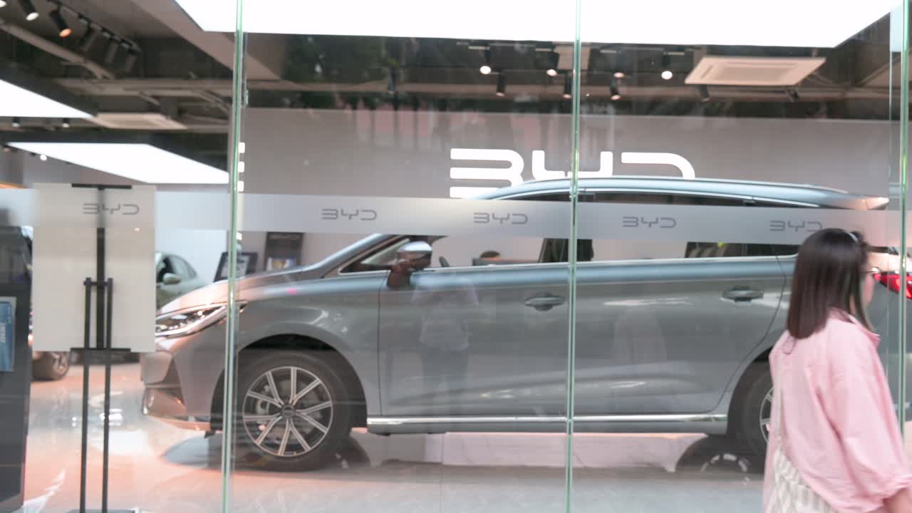 Pedestrians walk past the official authorized dealership of the Chinese automaker BYD.