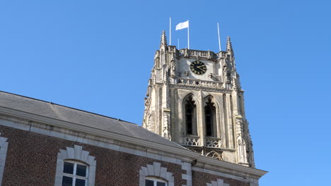 Zoom-in-on-Basilica-of-Our-Lady-Church-Tower-in-Tongeren,-Low-Angle