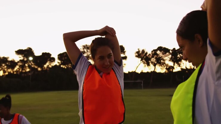 Female soccer players stretching their arms. 4k