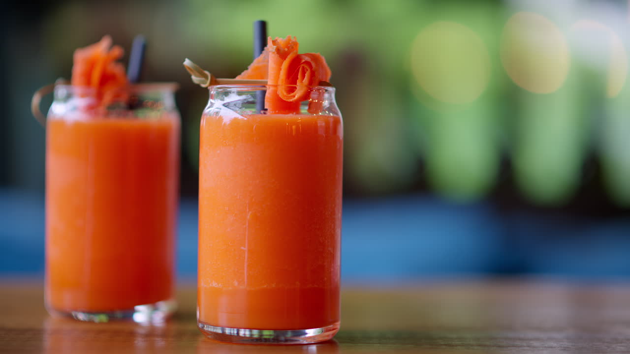 Two glasses of carrot juice, on the table at a restaurant