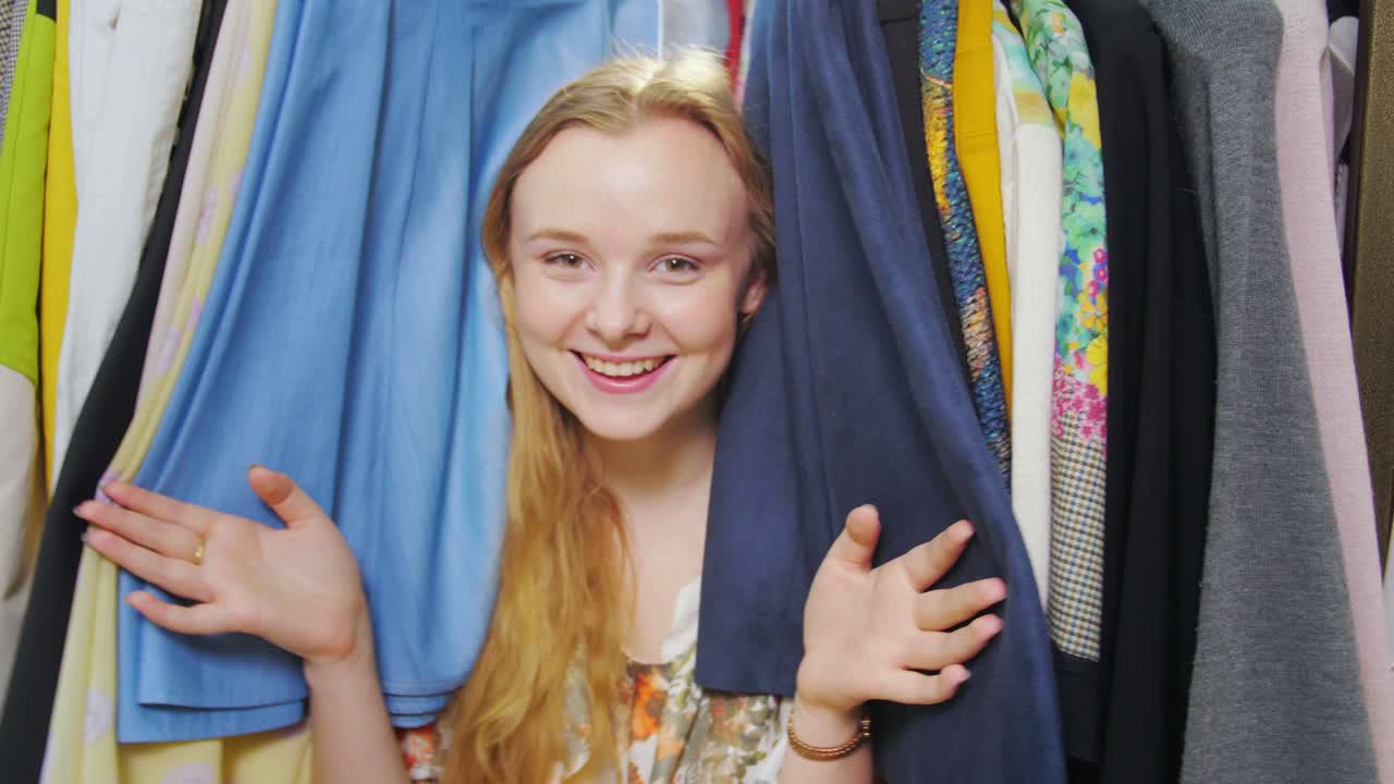 Woman choosing clothes from a full wardrobe