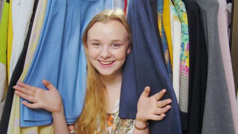 woman choosing clothes from a full wardrobe