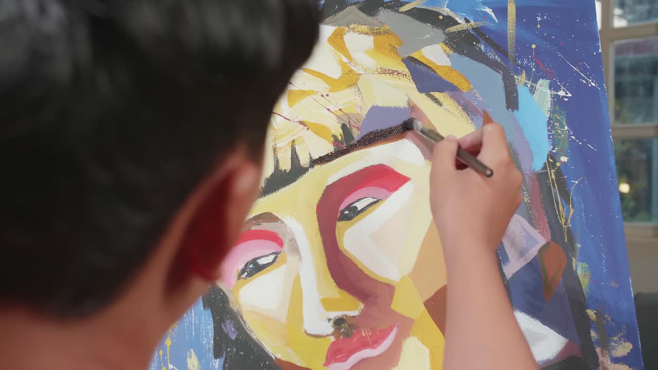Close Up Of An Asian Artist Boy Holding Paintbrush Mixed Colour And Painting A Girl'S Face On The Canvas