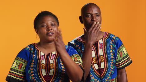 ethnic couple blowing air kisses in front of camera