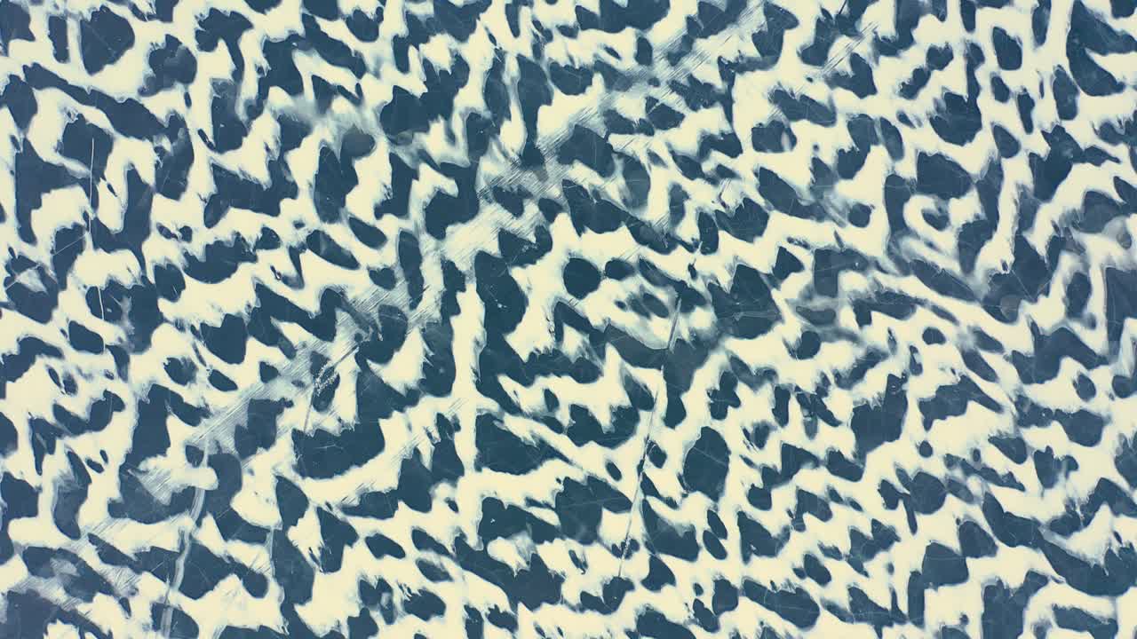 toma aérea de arriba hacia abajo volando hacia atrás alto sobre los patrones de nieve barridos por el viento en un lago congelado