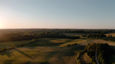 Aerial-sunset-landscape-scenery-above-farmland-and-forest-in-countryside