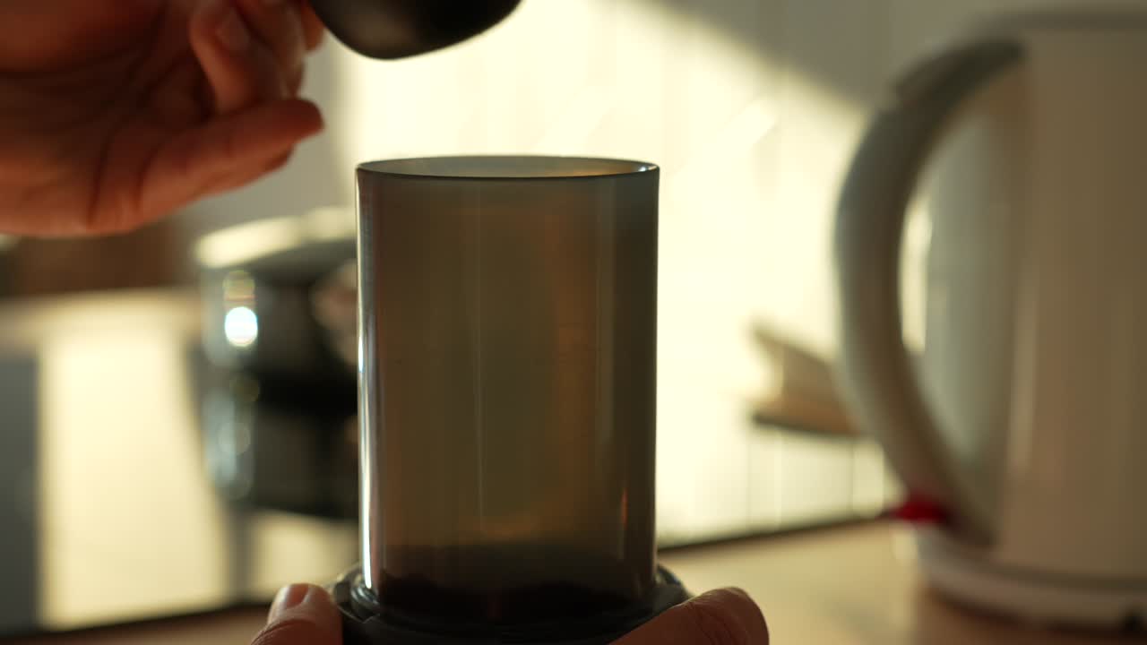 dejar caer café molido en una taza de aeroprés, en cámara lenta