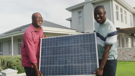 video of two african american men carrying the solar panel