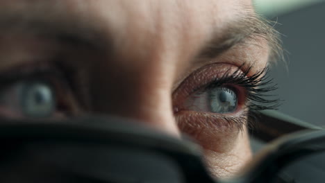 a close-up of a person's eyes, framed by glasses, with intense focus and detailed reflections