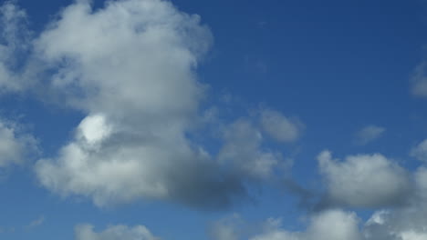 Zeitraffer-Weißer-Großer-Wolken,-Die-An-Blauen-Himmelsflecken-Vorbeiziehen