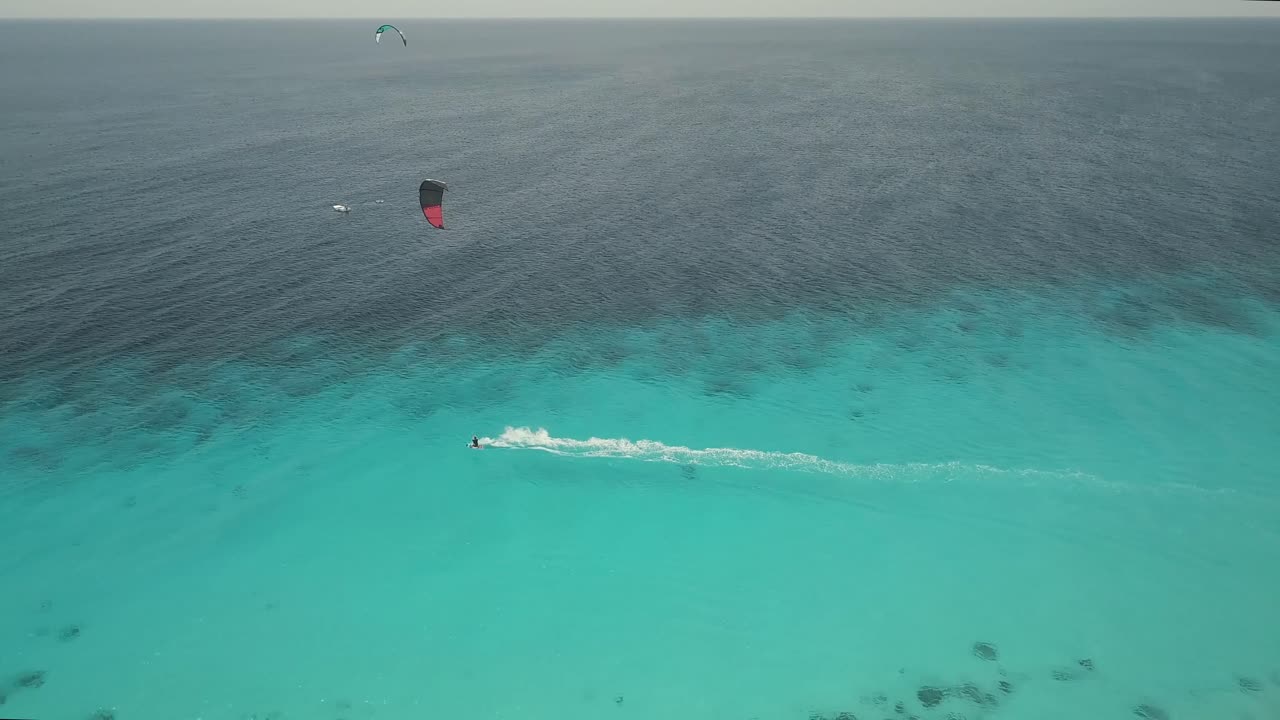 아름다운 청록색 바다에서 고속으로 타는 카이트서퍼의 드론 샷